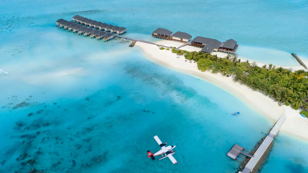Vista aerea di Summer Island Maldives con idrovolante, ville sull’acqua e laguna turchese