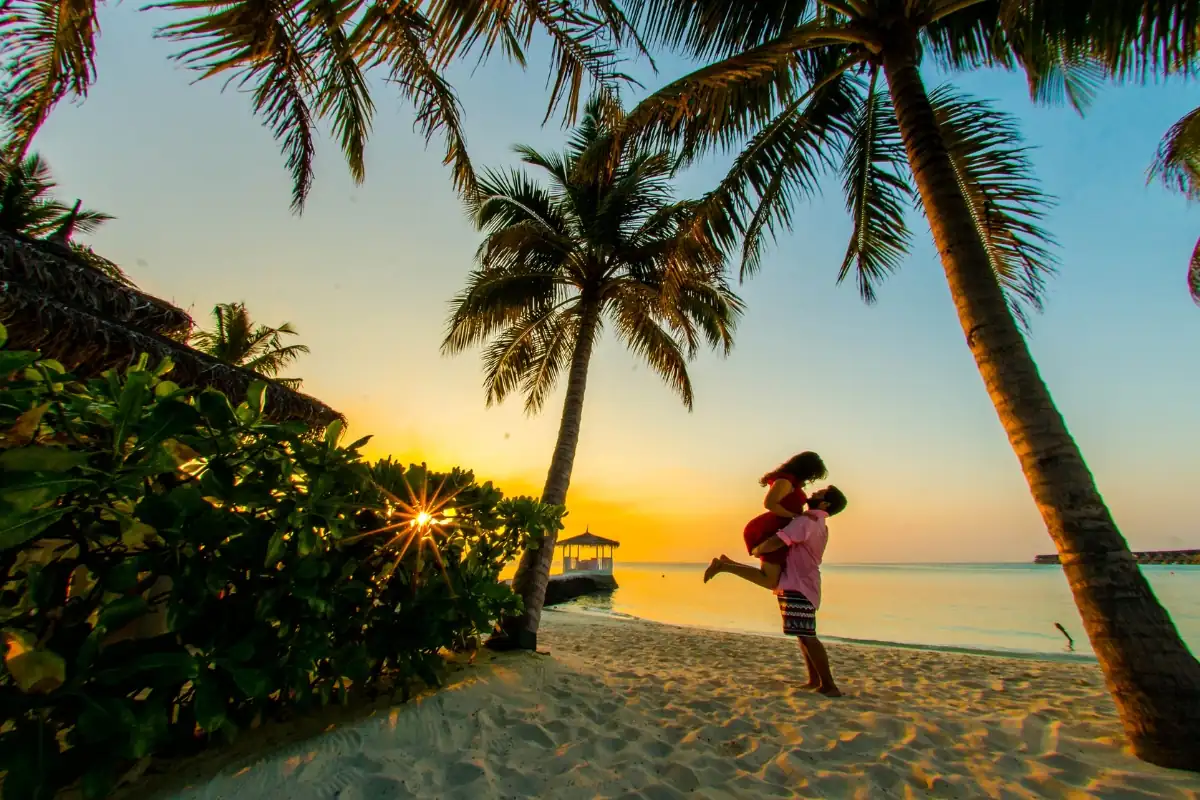 Coppia sulla spiaggia delle Maldive al tramonto